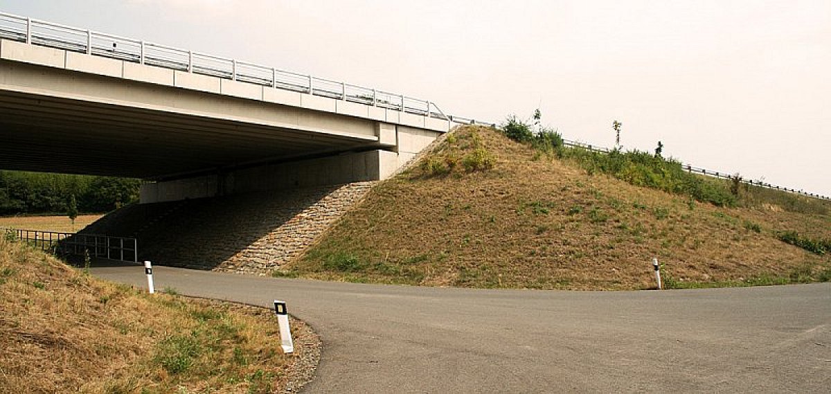 Passage sous le pont de l'autoroute, puis à droite et en montée